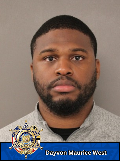 Mugshot of a man wearing a gray zip-up jacket against a plain background with a sheriff's badge and name label below.
