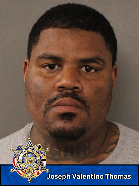 Booking photo of a man with plain background and Sheriff's Office badge
