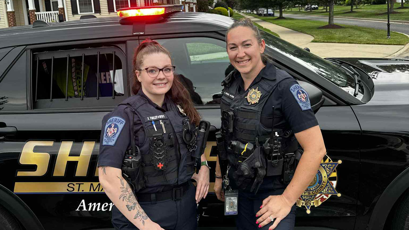 Officers standing in front of their vehicle
